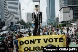 Boneka raksasa bergambar Pinokio ditarik oleh peserta demonstrasi yang diselenggarakan oleh berbagai organisasi kemanusiaan dan lingkungan serta mahasiswa di Jakarta pada 7 Februari 2024. (Foto: AFP/Yasuyoshi CHIBA)