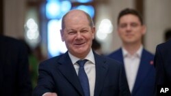 German Chancellor Olaf Scholz gestures as he arrives at the Party of European Socialists (PES) Leaders Conference, at the Palace of the Parliament, in Bucharest, Romania, April 6, 2024.