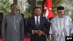 Togo President Faure Gnassingbé (M) is received by ECOWAS President Omar Touray (L) and Nigerian Minister of Foreign Affairs Yussuf Tuggar (R) during the extraordinary session of ECOWAS Heads of State and Government in Abuja, Nigeria on February 24, 2024.