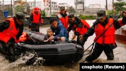 Paramilitary police officers evacuate residents stranded by floodwaters in Xincuo town of Fuqing city, after Typhoon Doksuri made landfall and brought heavy rainfall in Fuzhou, Fujian province, China, July 29, 2023. 