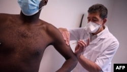 FILE - A man receives a dose of an Imvanex vaccine used to protect against Monkeypox virus at a Monkeypox vaccination site in Paris, France on August 3, 2022.