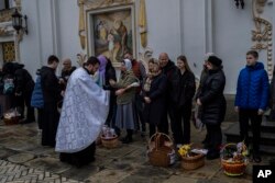 Orthodox Christian worshipers and their traditional Easter baskets are blessed during Easter Sunday at the Pechersk Lavra monastic complex Kyiv, Apr. 16, 2023.