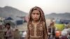 FILE — An Afghan refugee girl stands in a camp near the Torkham Pakistan-Afghanistan border in Torkham, Afghanistan, Nov. 4, 2023.