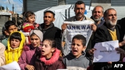 Palestinian men and children gather for a demonstration in Rafah in the southern Gaza Strip on Jan. 30, 2024, calling for continued international support to the United Nations Relief and Works Agency for Palestine Refugees in the Near East (UNRWA).