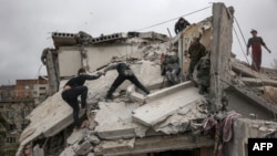 Rescuers and volunteers search for survivors on the top of a partially destroyed residential building, after a shelling in Sloviansk, Ukraine, on April 14, 2023.