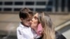Seorang perempuan tampak mencium anaknya setelah ia mengikuti proses pengambilan sumpah menjadi warga negara AS dalam upacara naturalisasi yang digelar di Perpustakaan Umum New York di Kota New York, pada 2 Juli 2024. (Foto: Reuters/Brendan McDermid)