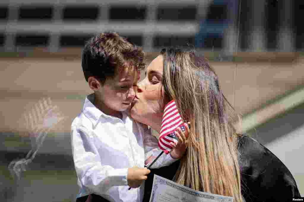 A woman kisses her child following her U.S. Citizenship and Immigration Services (USCIS) naturalization ceremony at the New York Public Library in New York City, July 2, 2024.