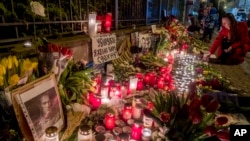 Flowers, candles and photos of Russian opposition leader Alexey Navalny are placed at the fence of the Russian Consulate in Frankfurt, Germany, Feb.17, 2024.