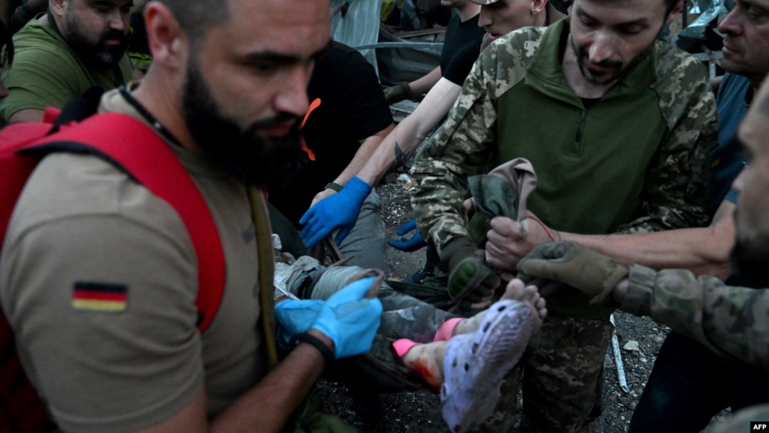 Rescuers and volunteers carry a person from the rubble created by a Russian missile attack on a restaurant and several houses in Kramatorsk, Ukraine, June 27, 2023.