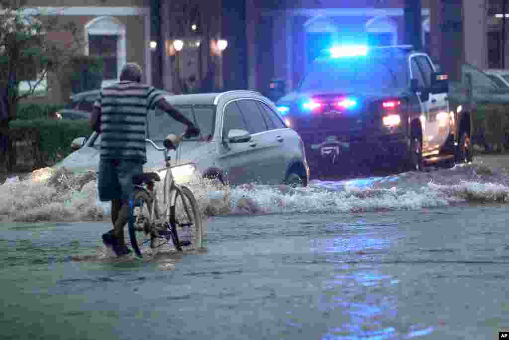 Un ciclista atraviesa calles inundadas en Stirling Road cerca de Federal Highway en Hollywood, Florida.