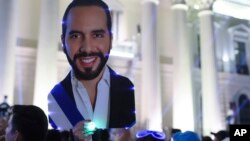 Supporters hold a cut of Salvador President Nayib Bukele as they gather to celebrate results of a general election at the Gerardo Barrios square in downtown San Salvador, El Salvador, Feb. 4, 2024. 