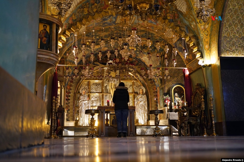 Una mujer reza en la Capilla Central del Calvario, en el Santo Sepulcro de Jerusalén, donde fue alzada la cruz en la que murió Jesús.