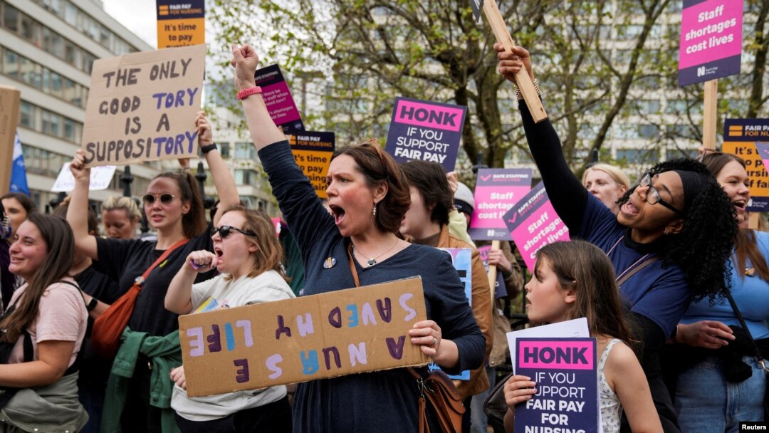 FILE - People chant as striking NHS healthcare staff take part in a protest march amid an ongoing dispute with the government over pay, in London, May 1, 2023. 