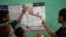 Teenager migrants look at a map of Mexico at the Peace Oasis of the Holy Spirit Amparito shelter in Villahermosa, Mexico, June 7, 2024.