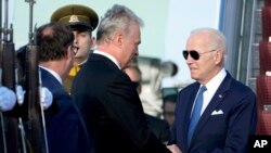 U.S. President Joe Biden is greeted by Lithuania's President Gitanas Nauseda as he arrives at Vilnius International Airport, in Vilnius, Lithuania, July 10, 2023.