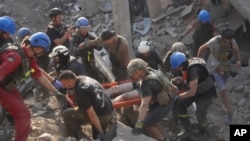 Rescuers carry a wounded man after a Russian missile attack on a sports complex in Kharkiv, Ukraine, Sept. 1, 2024.