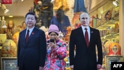 资料照片：莫斯科街头一家旅游纪念品商店外树立的中俄领导人纸板画像。（2023年11月15日）