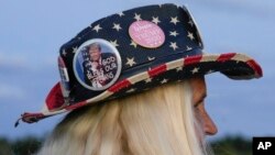 Kathy Clark of Lantana, Fla., wears an American flag hat with Trump pins as she shows her support for former President Donald Trump following the news that he has been indicted by a Manhattan grand jury, March 30, 2023, near Trump's Mar-a-Lago estate in Palm Beach, Fla.