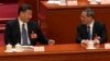 FILE - Chinese President Xi Jinping, left, chats with Chinese Premier Li Qiang during a session of China's National People's Congress at the Great Hall of the People in Beijing, March 12, 2023.