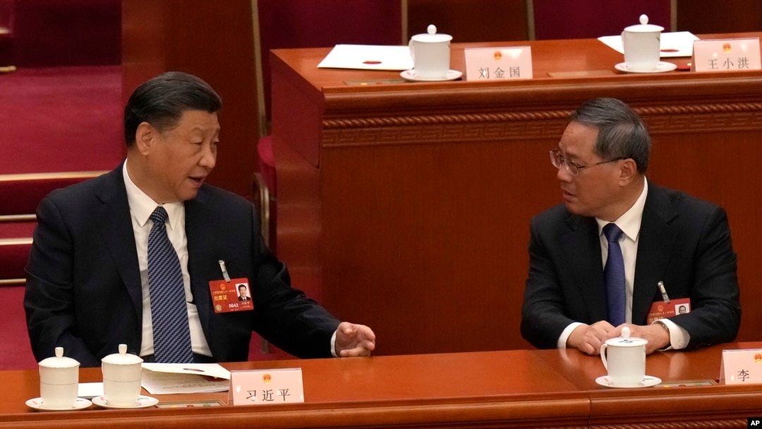 FILE - Chinese President Xi Jinping, left, chats with Chinese Premier Li Qiang during a session of China's National People's Congress at the Great Hall of the People in Beijing, March 12, 2023.
