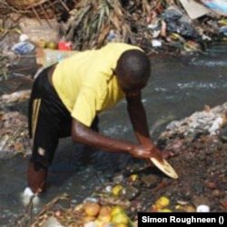 Street child in Freetown gathers food (Photo: Simon Roughneen)