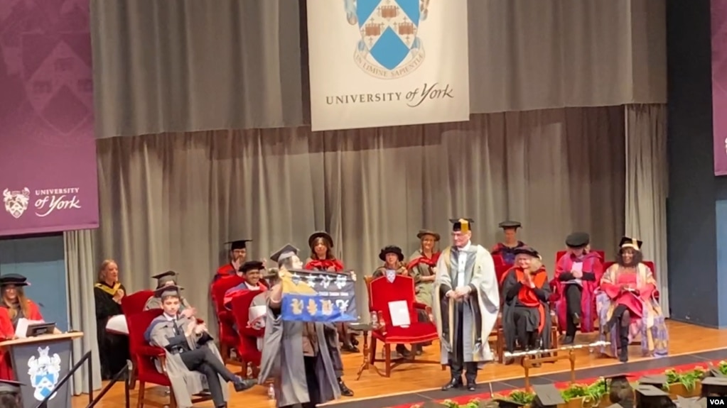 2月7日中国异见人士马有为在英国约克大学毕业典礼上挥舞自由香港旗帜 (美国之音/李伯安)(photo:VOA)