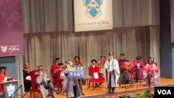 2月7日中國異議人士馬有為在英國約克大學畢業典禮上揮舞自由香港旗幟(美國之音/李伯安)