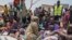 FILE - South Sudanese who fled from Sudan sit outside a nutrition clinic at a transit center in Renk, South Sudan, May 16, 2023.