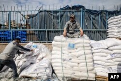 FILE —A worker rests as displaced Palestinians receive food aid at the United Nations Relief and Works Agency for Palestine Refugees center in Rafah on January 28, 2024.