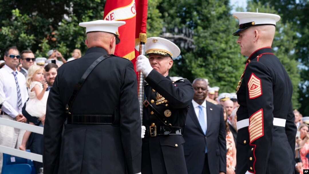 U.S. Marine Corps Gen. David Berger, left, hands the battle colors to Gen. Eric Smith during a relinquishment of office ceremony, at the Marine Barracks in Washington, July 10, 2023. 