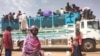 FILE - People board a truck as they leave Khartoum, Sudan, on June 19, 2023.