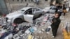 Palestinians inspect damaged vehicles at the site of an Israeli strike in Rafah in the southern Gaza Strip, Feb. 9, 2024.