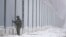 FILE - A Polish border guard stands next to the border wall in Nomiki in November 2022. Poland’s governing party is being rocked by reports that Polish consulates issued visas in Africa and Asia in exchange for bribes, opening the door for migrants to enter the EU.
