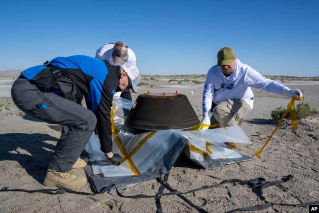 In this NASA photo, members of a recovery team from Lockheed Martin prepare to transport the asteroid sample, which touched down at the Department of Defense's Utah Test and Training Range on Sunday, Sept. 24, 2023. (Keegan Barber/NASA via AP)