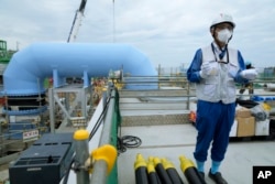 Tomohiko Mayuzumi, a spokesperson of Tokyo Electric Power Company Holdings, also known as TEPCO, speaks during a tour of the Fukushima Daiichi nuclear power plant in Futaba town, Japan, July 14, 2023.