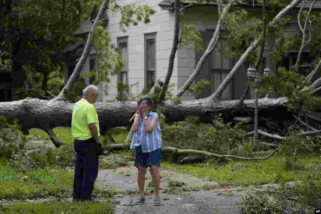 Jackie Jecmenek, right, talks with city worker Bobby Head as she stands in front of her neighbor&#39;s home after Hurricane Beryl passed, July 8, 2024, in Bay City, Texas.