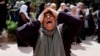 资料照片：2023年10月12日，在以色列占领的约旦河西岸纳布卢斯附近，一名妇女在为与以色列定居者冲突中丧生的四名巴勒斯坦人举行的葬礼上哀哭。（路透社照片）
