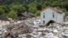 Petugas penyelamat memeriksa lokasi tanah longsor akibat cuaca buruk dan hujan lebat di lembah Misox, di Desa Sorte, Lostallo, Swiss selatan pada Minggu 23 Juni 2024. (Foto: via AP)