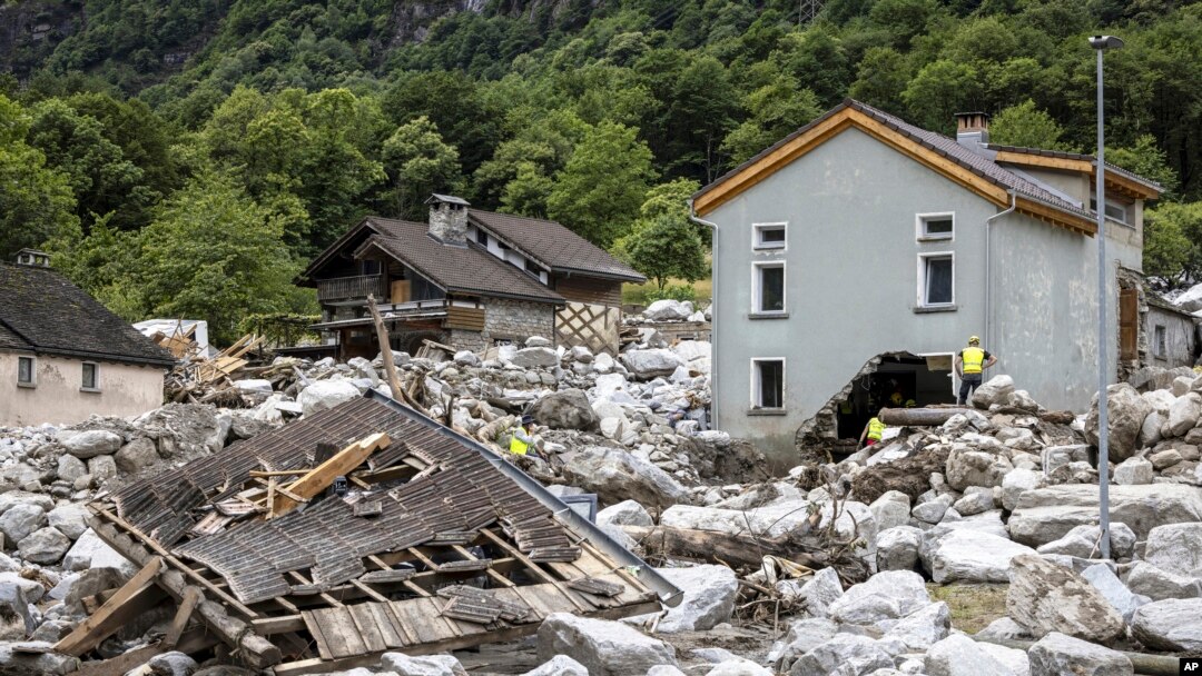 Rescue workers inspect the site of a landslide, caused by severe weather and heavy rain in the Misox valley, in Sorte village, Lostallo, southern Switzerland, June 23, 2024.
