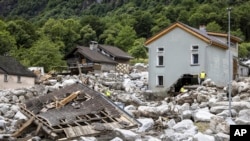 Rescue workers inspect the site of a landslide, caused by severe weather and heavy rain in the Misox valley, in Sorte village, Lostallo, southern Switzerland, June 23, 2024.