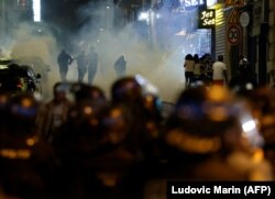 Sejak pedemo lari kocar-kacir setelah ditembak gas air mata oleh polisi di Paris, Minggu, 2 Juli 2023, lima hari setelah seorang remaja tewas ditembak polisi di Nantarre, pinggiran Kota Paris. (Foto: Ludovic Marin/AFP)