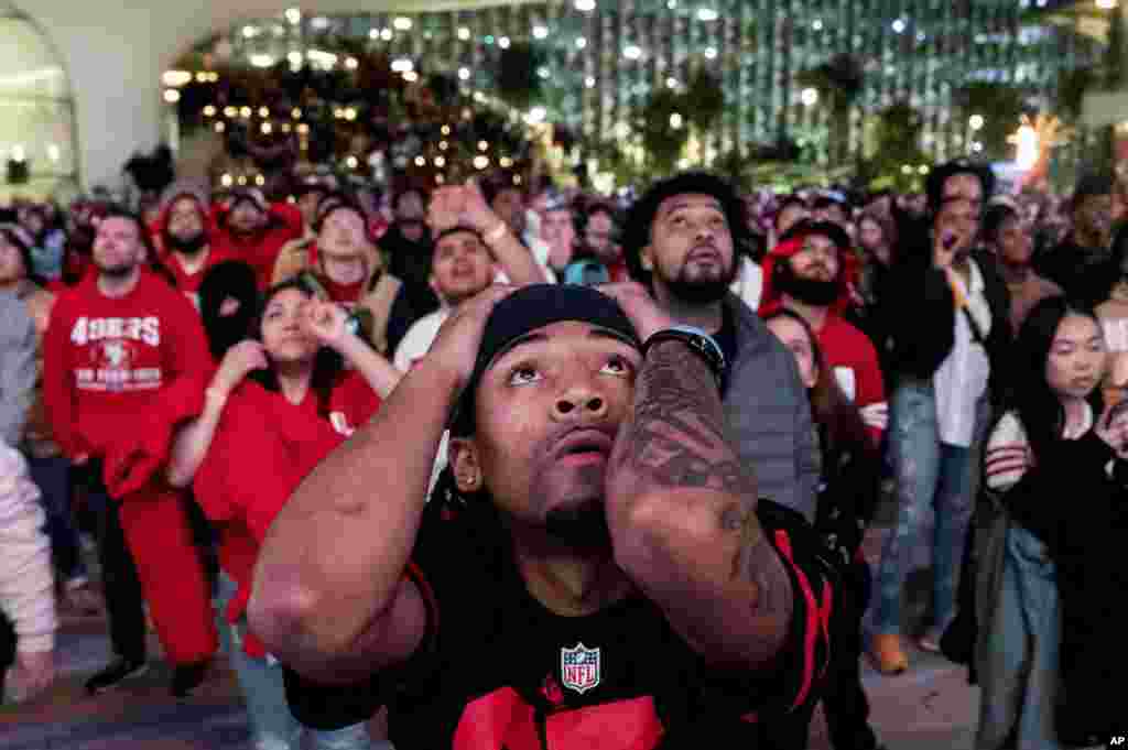 San Francisco 49ers fans react during overtime play while watching a telecast of NFL football's Super Bowl 58 on a screen outside the Chase Center in San Francisco, Feb. 11, 2024.