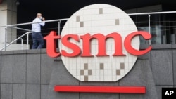 FILE - A person walks into the Taiwan Semiconductor Manufacturing Co., headquarters in Hsinchu, Taiwan, Oct. 20, 2021. 