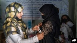 FILE - An Afghan woman is checked by a nutritionist at a clinic run by the World Food Program, in Kabul, Afghanistan, Jan. 26, 2023. The Taliban has restricted the rights of Afghan women, including prohibiting Afghan women from working for the United Nations in Afghanistan.