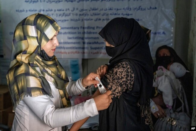 FILE - An Afghan woman is checked by a nutritionist at a clinic run by the WFP, in Kabul, Afghanistan, Jan. 26, 2023.