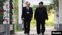 19일 북한을 방문 중인 블라디미르 푸틴 러시아 대통령과 김정은 북한 국무위원장이 평양 해방기념탑에서의 헌화식에 앞서 함께 걷고 있다.