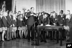 Graphic DescriptionFILE - President Richard Nixon signs the Constitution's newest amendment which guarantees 18-year-olds the right to vote in all elections in East Room of the White House in Washington on July 4, 1971. (AP Photo/Charles Tasnadi, File)