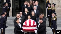 The flag-draped casket of retired Supreme Court Justice Sandra Day O'Connor departs the National Cathedral in Washington, following a memorial service, Dec. 19, 2023. 