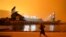 FILE - A jogger runs along McCovey Cove outside Oracle Park in San Francisco, under darkened skies from wildfire smoke on Sept. 9, 2020. 