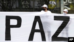 Excombatientes de las disueltas FARC y activistas sociales participan en una marcha para exigir que el gobierno garantice su derecho a la vida y el cumplimiento del acuerdo de paz de 2016, en Bogotá, Colombia, el domingo 1 de noviembre de 2020.